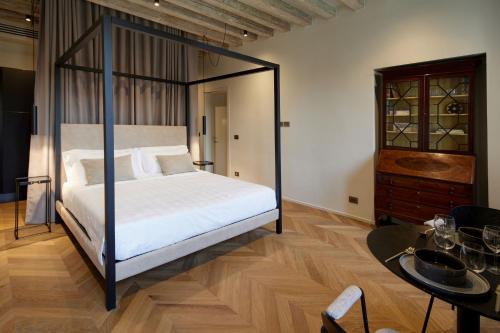 a bedroom with a canopy bed and a table at Palazzina RIVA in Venice