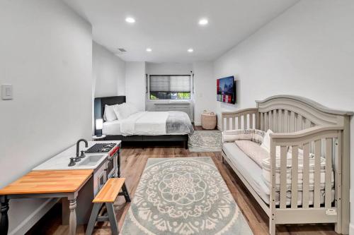 um quarto com uma cama e um berço em King Suite, Kid Friendly, w/ Pool & Basketball! em Los Angeles