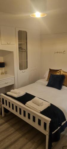 1 dormitorio con 2 camas y escritorio en The Manor Guest House in Wembley, en Londres