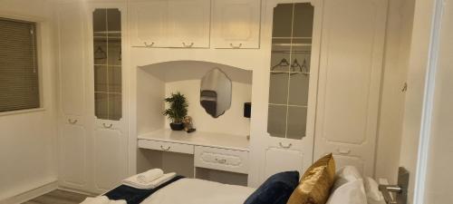 a white room with a bed and a counter at The Manor Guest House in Wembley in London
