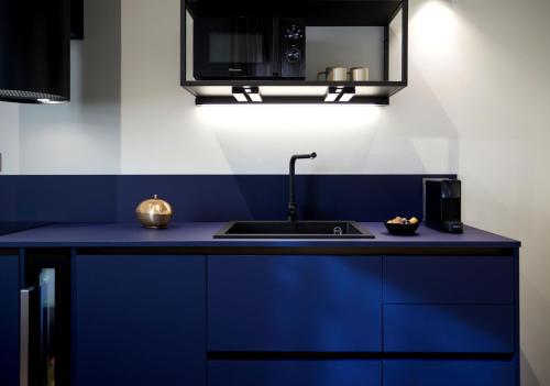 a kitchen with blue cabinets and a sink at Palazzina RIVA in Venice
