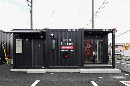a black building with a sign on the side of it at HOTEL R9 The Yard 倉敷 in Kurashiki