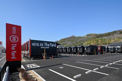 an empty parking lot with a row of trailers at HOTEL R9 The Yard 倉敷 in Kurashiki