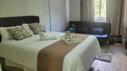 a bedroom with a bed with a tray on it at HOTEL CAVALINHO BRANCO in Águas de Lindóia
