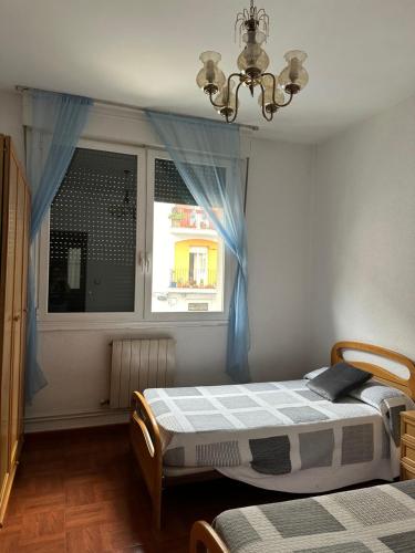 a bedroom with two beds and a window at Pension Vista Alegre in Bilbao