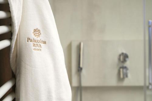 a white towel with a logo on it next to a bathroom at Palazzina RIVA in Venice