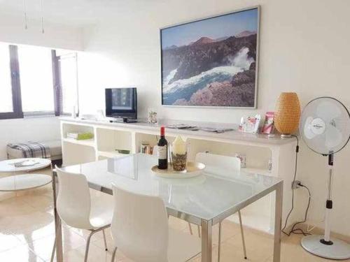 ein Wohnzimmer mit einem weißen Tisch und weißen Stühlen in der Unterkunft El Reducto Suite in Arrecife