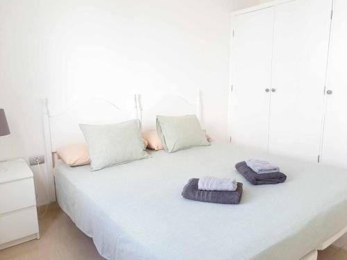 ein weißes Bett mit zwei Handtüchern darüber in der Unterkunft El Reducto Suite in Arrecife