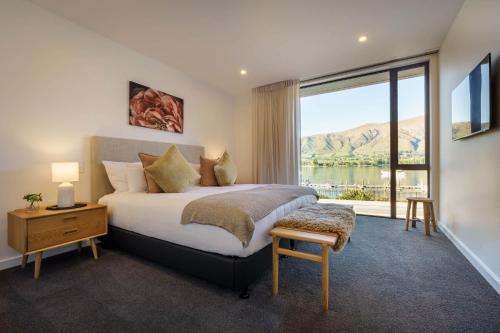 1 dormitorio con cama y ventana grande en Marina Terrace, Wanaka, en Wanaka