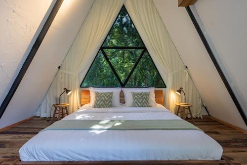 Daya Villa في كامبوت: سرير في غرفة مع نافذة كبيرة