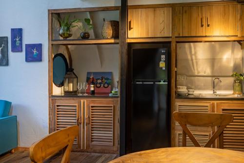 a kitchen with a black refrigerator and wooden cabinets at Daya Villa in Kampot