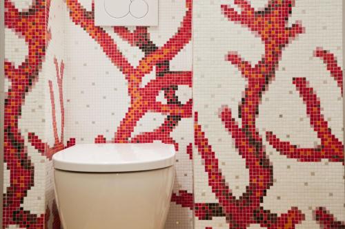 a bathroom with a toilet with a mosaic wall at Palazzina RIVA in Venice