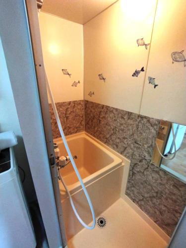 a small bathroom with a tub and a shower at E-Horizon北2条 in Sapporo