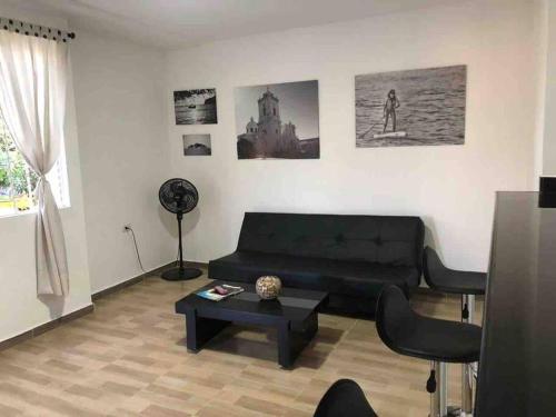 uma sala de estar com um sofá preto e uma mesa em Apartasuite 10-72. 2 em Santa Marta