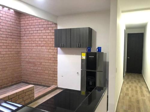 uma cozinha com um frigorífico e uma parede de tijolos em Apartasuite 10-72. 2 em Santa Marta