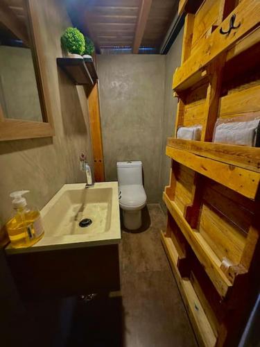 a small bathroom with a toilet and a sink at Casa del árbol - Mitad del mundo in Quito