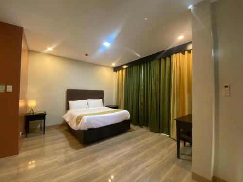 a bedroom with a bed and a green curtain at Eight Breeze in Baclayon