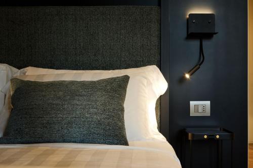 a bed with a black and white pillow and a lamp at Palazzina RIVA in Venice
