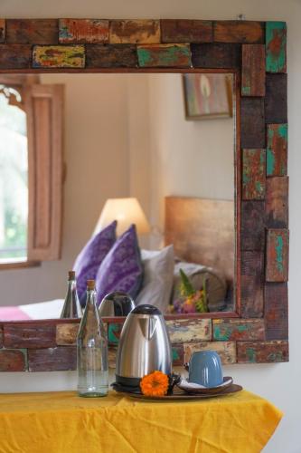 a mirror on top of a table with a tea kettle at Nirwa 1 Ubud Guesthouse in Ubud