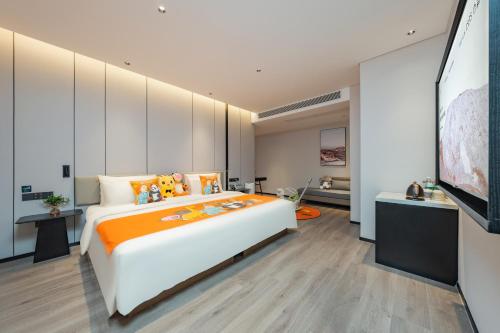 a bedroom with a large bed with an orange blanket at Atour Hotel Guangzhou Pazhou Exhibition Center Information Port-Free shuttle bus to Canton Fair in Guangzhou