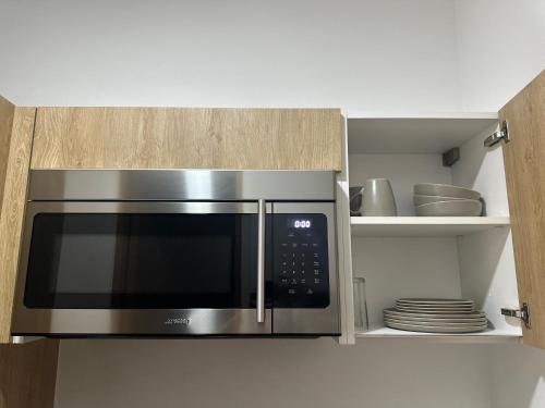 a stainless steel microwave oven in a kitchen at Smart Home Luxury Condo 5ta avenida in Playa del Carmen