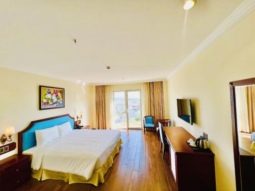 a bedroom with a bed and a desk and a window at CALYSSA HOTELS & VILLAGE in Khu Chi Lăng