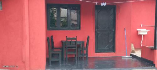 un edificio rojo con una mesa y sillas frente a una puerta en Estanislao López 127 en Puerto Iguazú