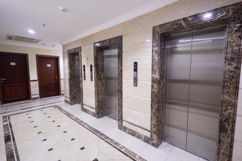 a hallway with elevator doors in a building at شقق مجد نوران الفندقية محبس الجن مكة in Makkah