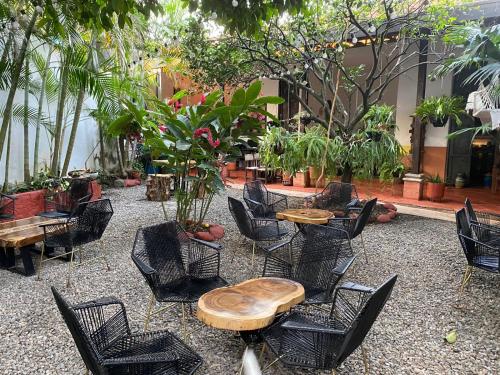 eine Terrasse mit Tischen, Stühlen und Pflanzen in der Unterkunft Hotel Doña Hilda in San Martín