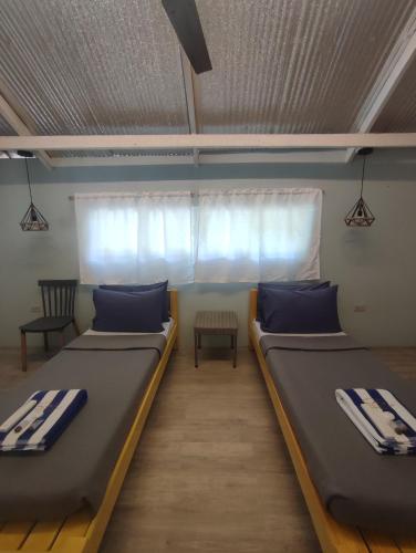 two beds in a room with a window at Caliraya Mountain Lake Resort in Cavinti