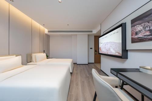 a hotel room with two beds and a flat screen tv at Atour Hotel Guangzhou Pazhou Exhibition Center Information Port-Free shuttle bus to Canton Fair in Guangzhou