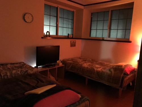 平川市にあるMisato Memorial Hall - Vacation STAY 61405vのベッド2台、薄型テレビが備わる客室です。