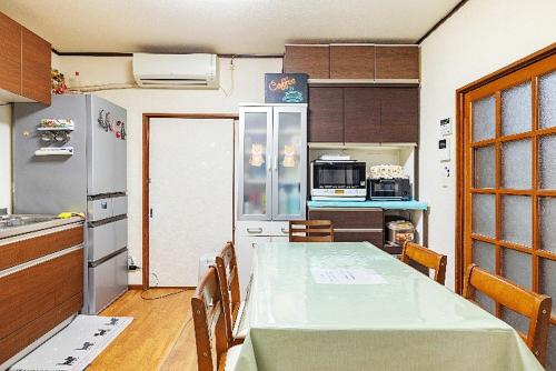 eine kleine Küche mit einem Tisch und einem Kühlschrank in der Unterkunft Takeuchi Goya in Chiba