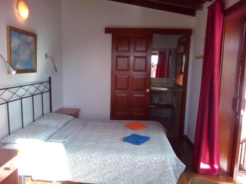 1 dormitorio con 2 camas y cortina roja en Casa Marilan, en Santa Cruz de la Palma