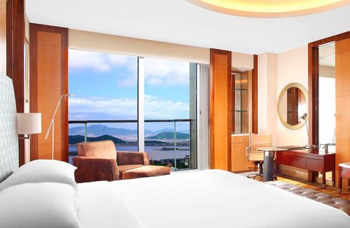 a bedroom with a bed and a view of the ocean at Sheraton Zhoushan Hotel in Zhoushan