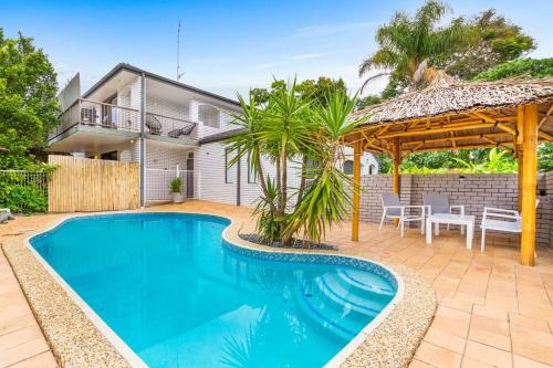 a swimming pool in front of a house at Paradise Villas- Villa 1 in Gold Coast