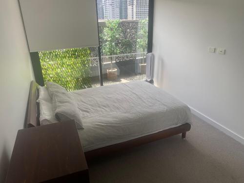 een bed in een kamer met een groot raam bij Spacious 2 bed apartment, great location in Melbourne