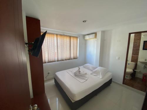 Un dormitorio con una cama con una toalla. en HOTEL SAN ÁNGEL VILLAVICENCIO, en Villavicencio