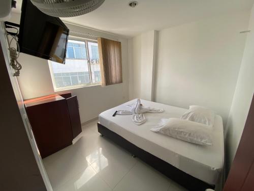 - une chambre avec un lit et une télévision à écran plat dans l'établissement HOTEL SAN ÁNGEL VILLAVICENCIO, à Villavicencio