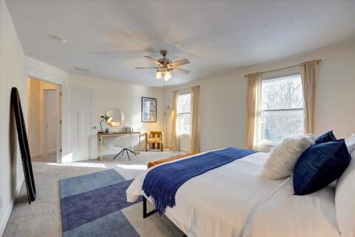 een slaapkamer met een bed, een plafondventilator en een bureau bij Newly Built Oasis close to IU 4bd/2.5ba in Bloomington