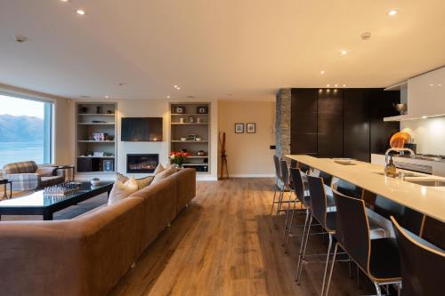 uma ampla sala de estar com um sofá e um bar em Lordens Apartment 1 em Queenstown