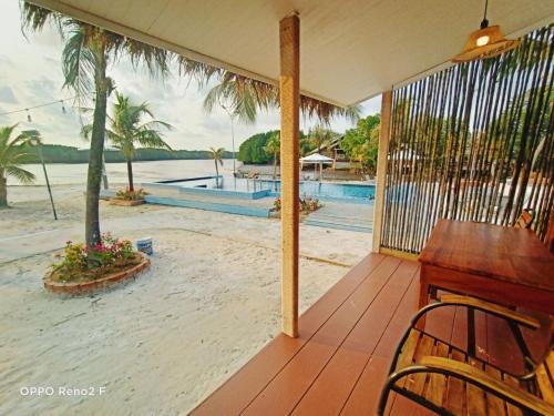 a porch with a piano and a view of the beach at Nov Koh Kong Resort in Phumĭ Srê Thmei