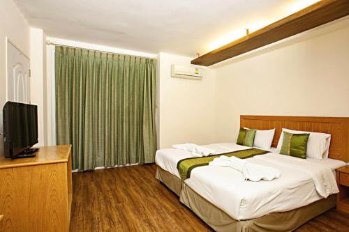 a hotel room with two beds and a television at TM Land Hotel in Phra Nakhon Si Ayutthaya