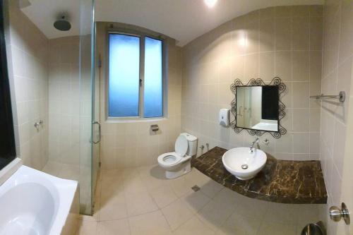 a bathroom with a toilet and a sink and a mirror at Sky Residence -3 Bedrooms Condo at Cinta Sayang, Sungai Petani in Sungai Petani