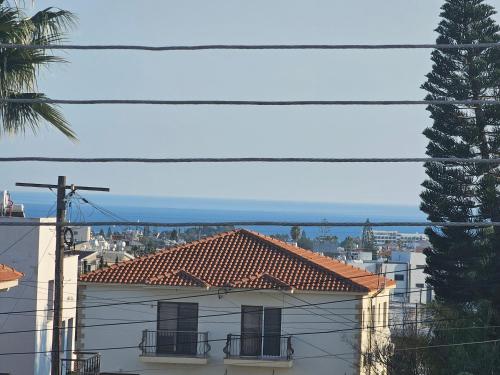 a building with a red tile roof and a palm tree at STEFARIS sea & mountain view in Larnaka