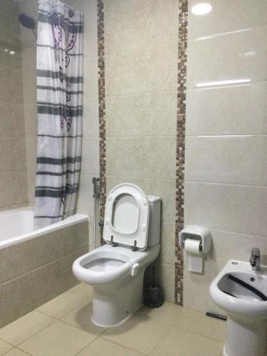 a bathroom with a toilet and a sink at 1 bedroom apartment in Fujairah