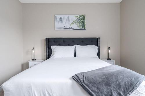 1 dormitorio con 1 cama blanca grande y 2 lámparas en Peaceful Modern Home near Avon, en Avon
