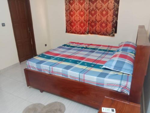 1 dormitorio con 1 cama con manta a cuadros en La Résidence Lia, en Porto Novo