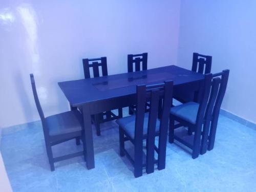 mesa de comedor negra con sillas y mesa negra en La Résidence Lia, en Porto Novo