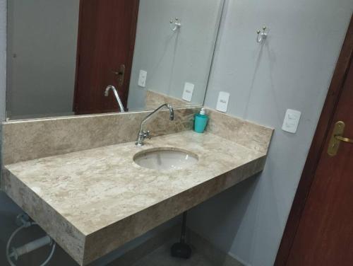 a bathroom counter with a sink and a mirror at Recanto Girassol em São Roque - Rota do Vinho in São Roque